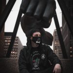 man in black jacket wearing black sunglasses sitting on black leather chair