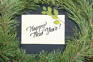 a happy new year's card on top of a pine tree